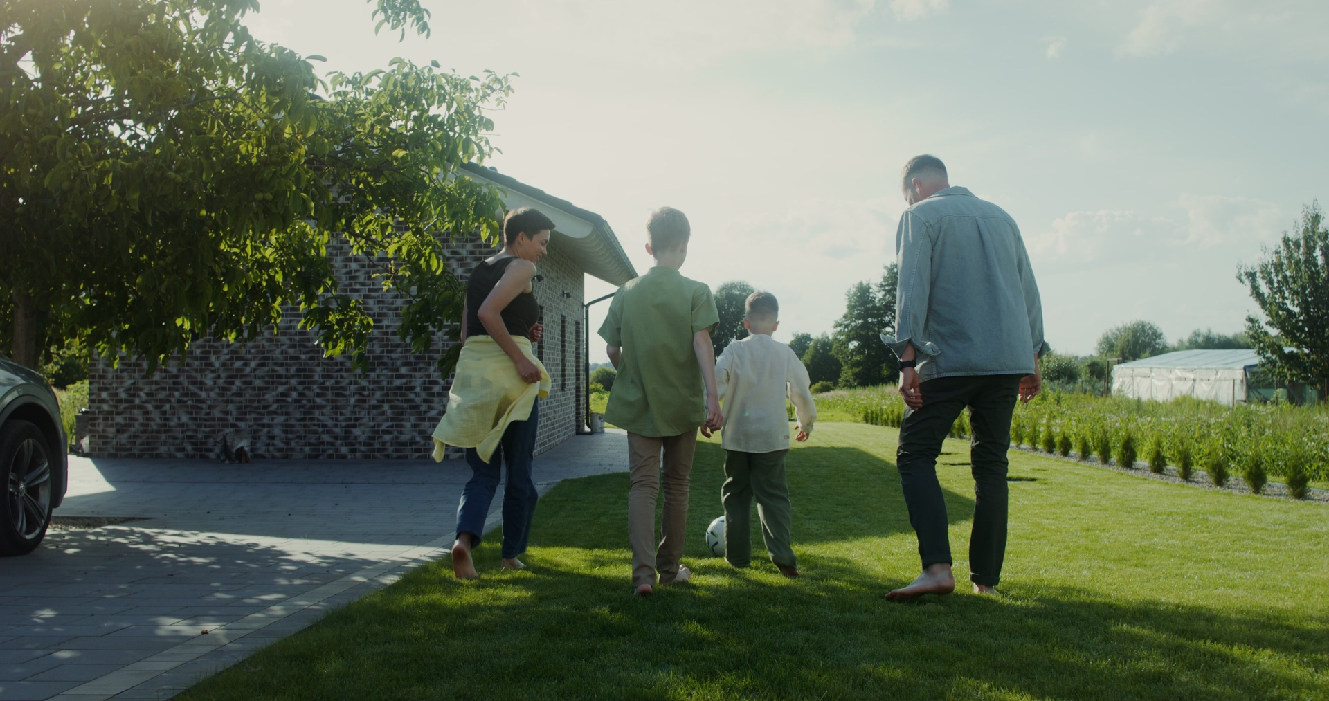 family enjoying a lush spring lawn because they had greenbelt lawns aerate and overseeding their lawn in the fall